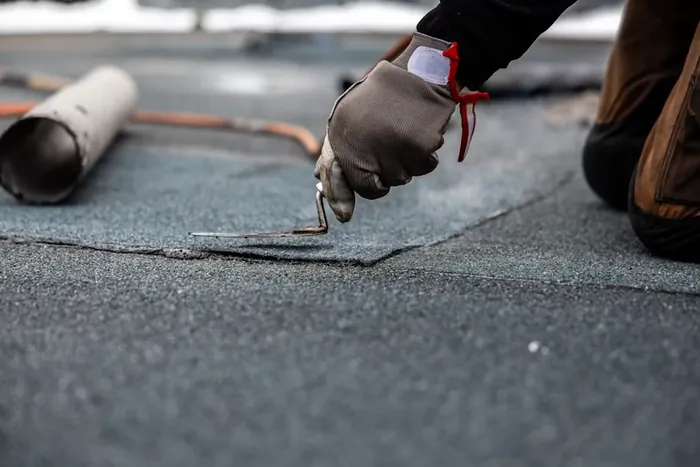 Roofer applying waterproofing membrane sealant in Lebanon